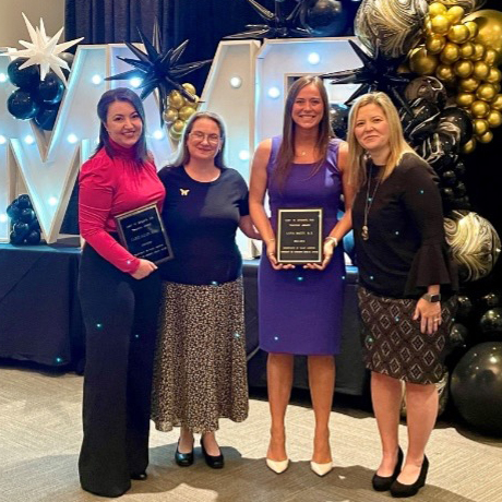 Carrie Allen and Ann McCoy stand with two faculty members holding awards.